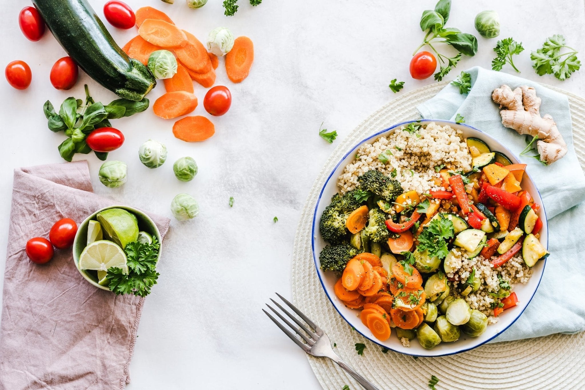 Colorful vegetable medley with quinoa and fresh ingredients on a marble countertop.