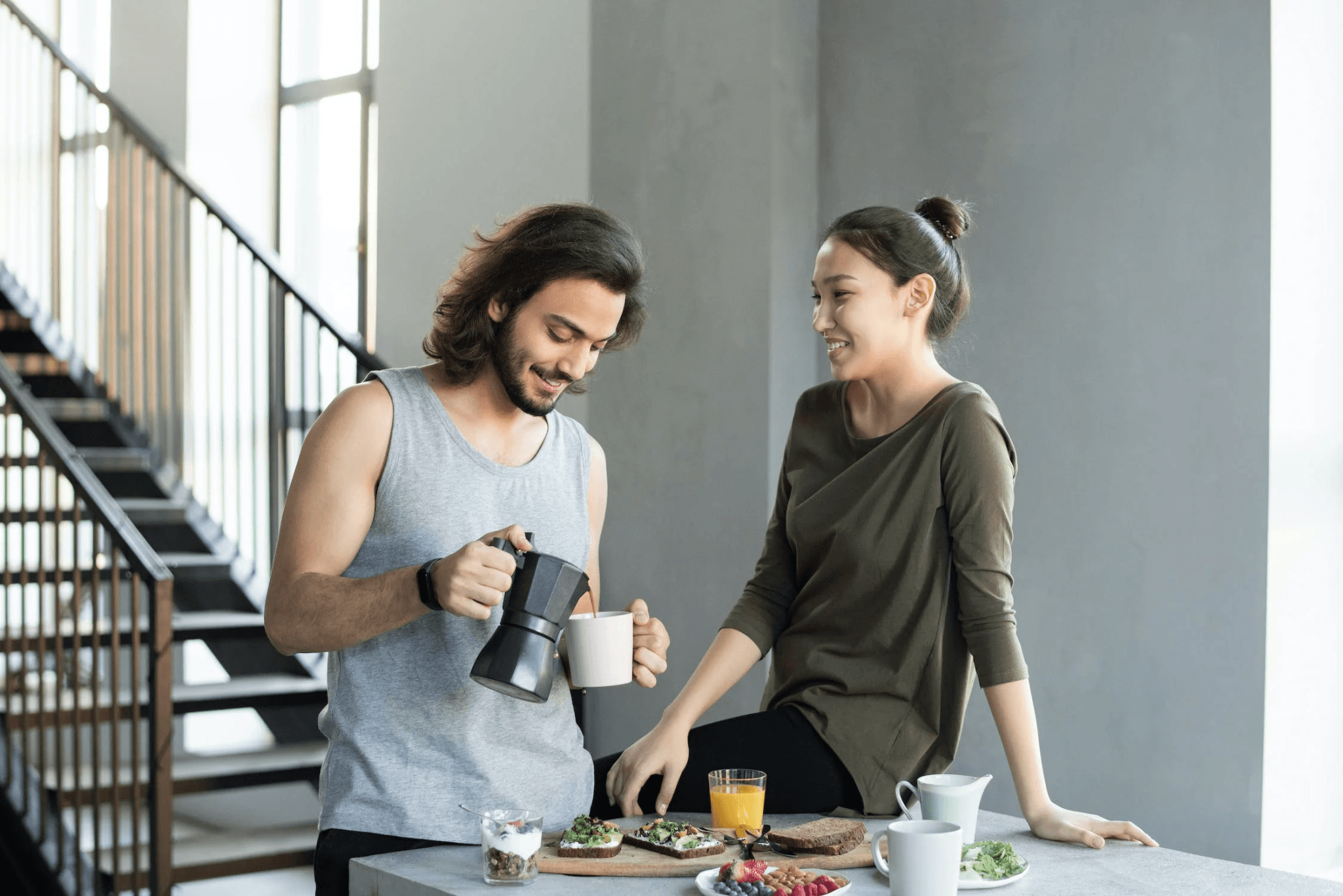 two people enjoying breakfast with coffee and juice in a modern kitchen