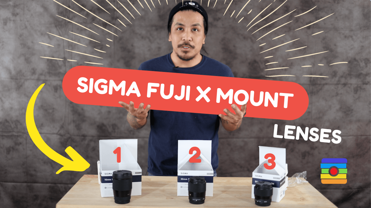 Sigma Fuji X Mount lenses arranged on a table with a person presenting them.