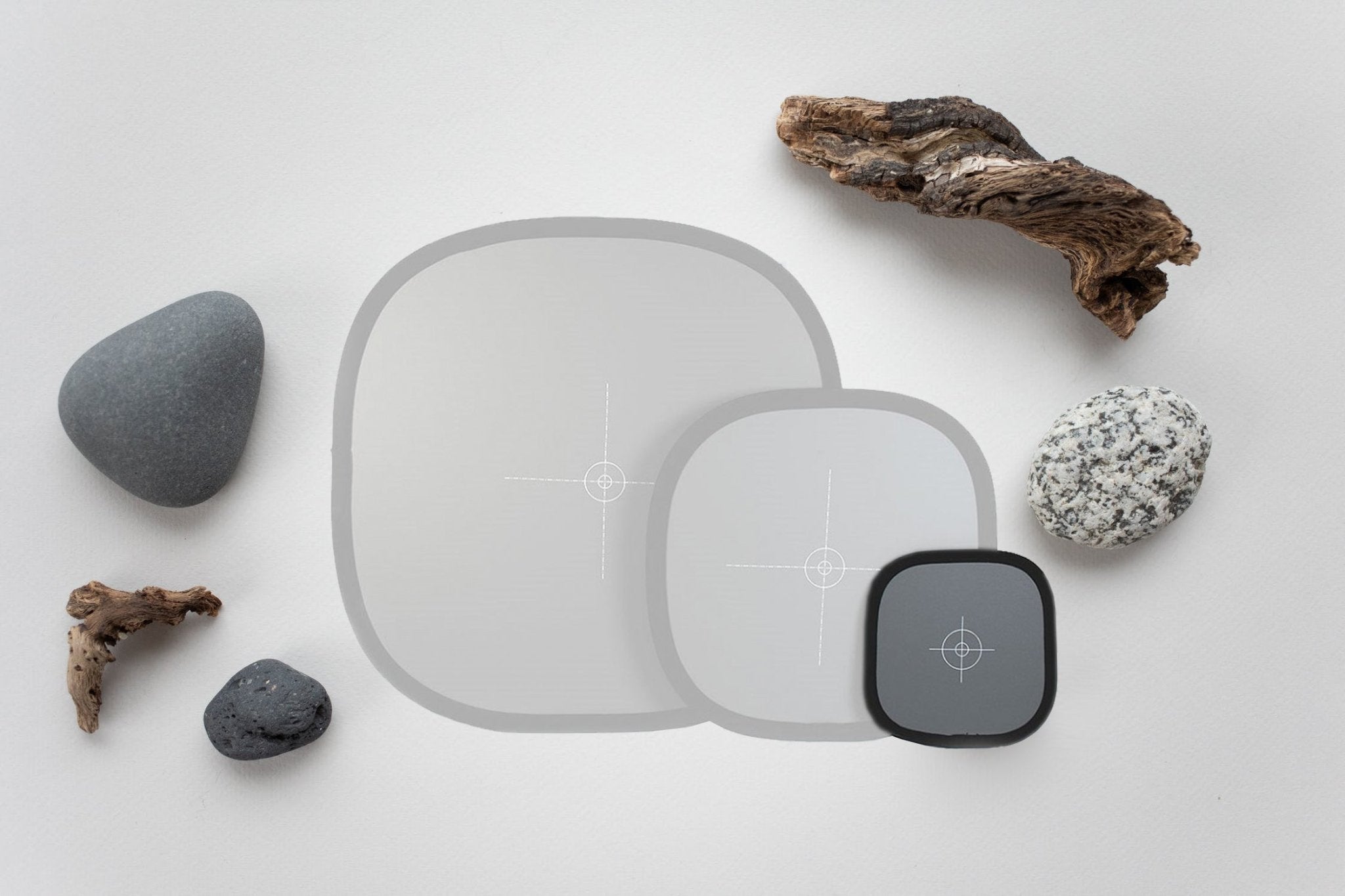 Neutral gray and white balance cards on a light background with pebbles and driftwood