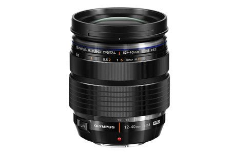 Black Olympus mirrorless lens with a silver ring and specifications on the barrel.