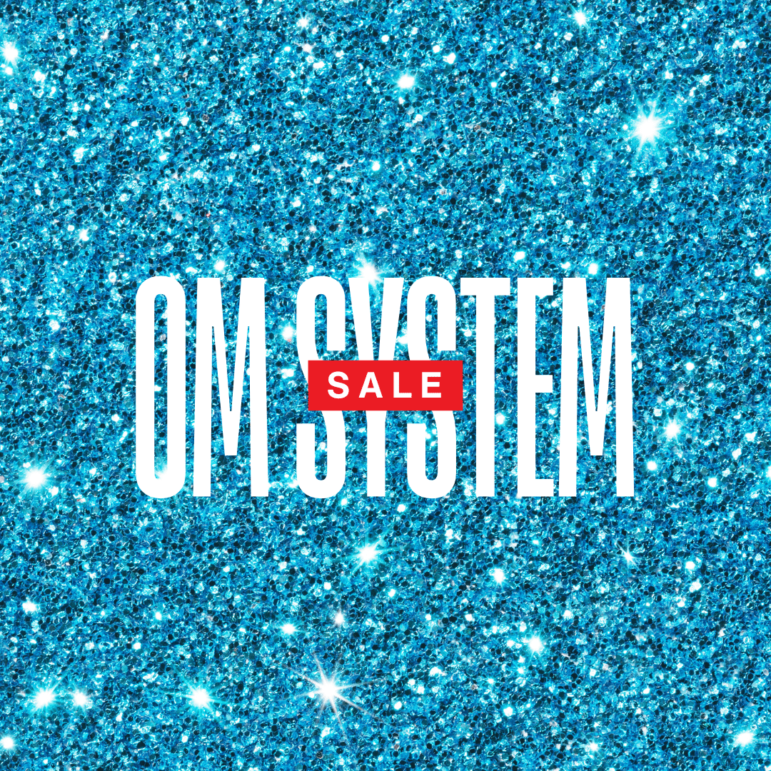 Blue glitter background with bold white text reading OM SYSTEM and red SALE.