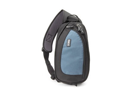 Black and blue sling bag with a textured front pocket and padded strap.